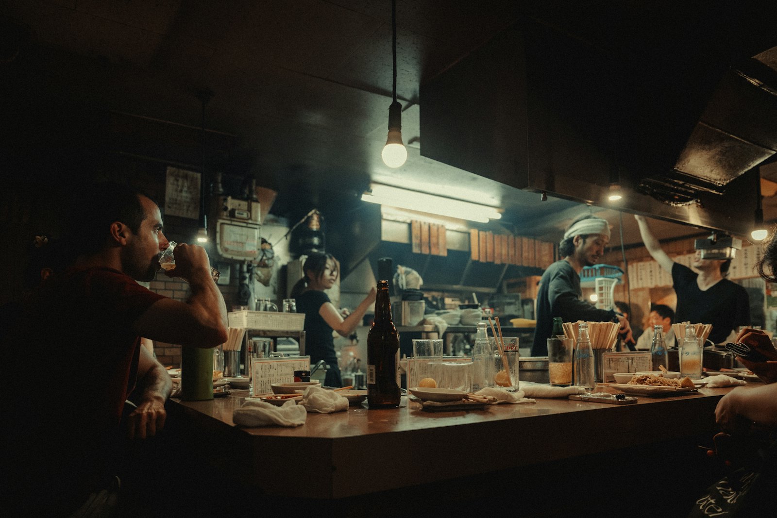 บรรยากาศร้านอิซากายะช่วงค่ำ พนักงานทำงานในครัวเปิด